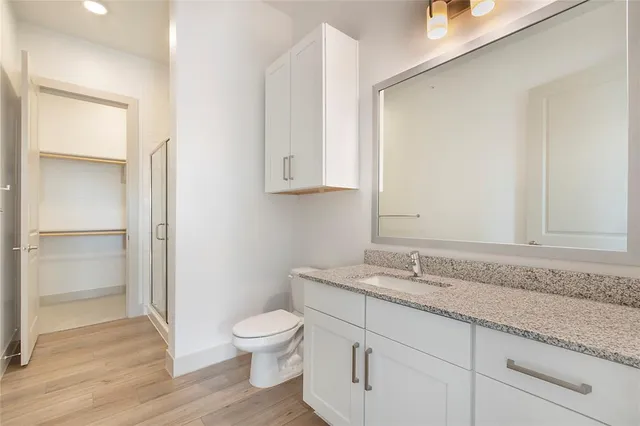 a bathroom with a granite countertop sink and a toilet