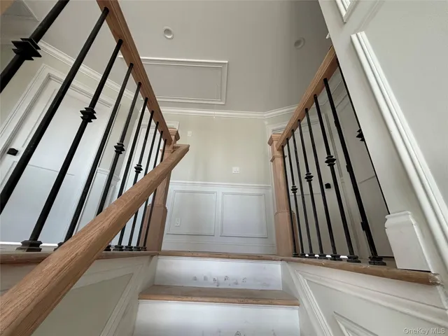 a view of staircase with white walls and black white door