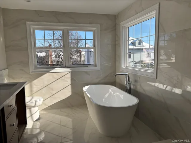 a bathroom with a granite countertop shower a toilet and a sink