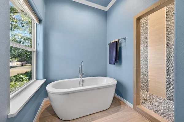 a white bath tub sitting in a bathroom next to a window
