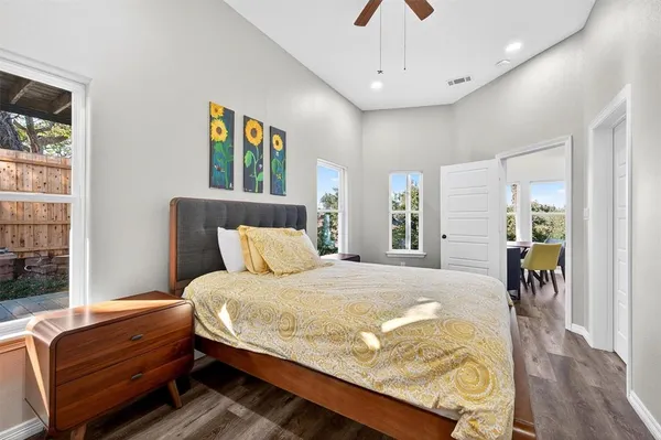 a bedroom with a bed dresser and wooden floor