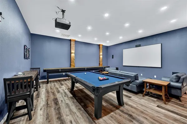 a room with furniture pool table and a projector