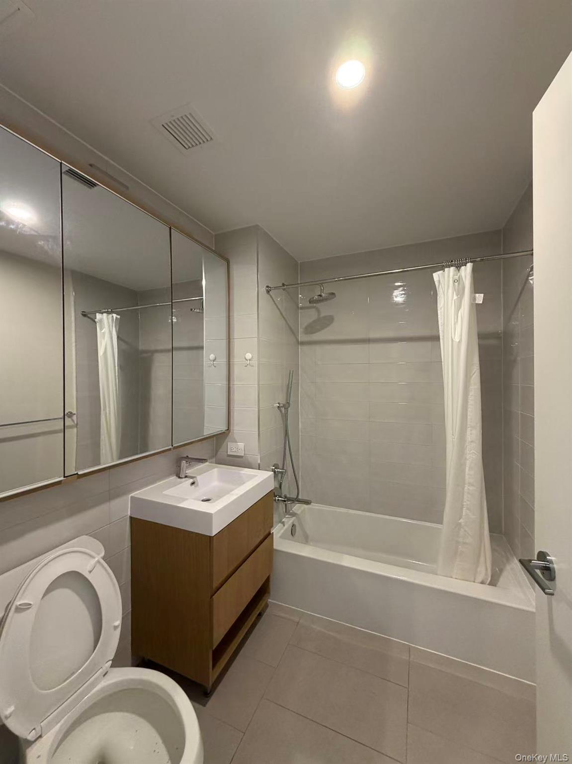 131-02 40th Road, Unit 7O Queens, NY 11354 - Photo 5 of 7 a bathroom with a sink a toilet and shower