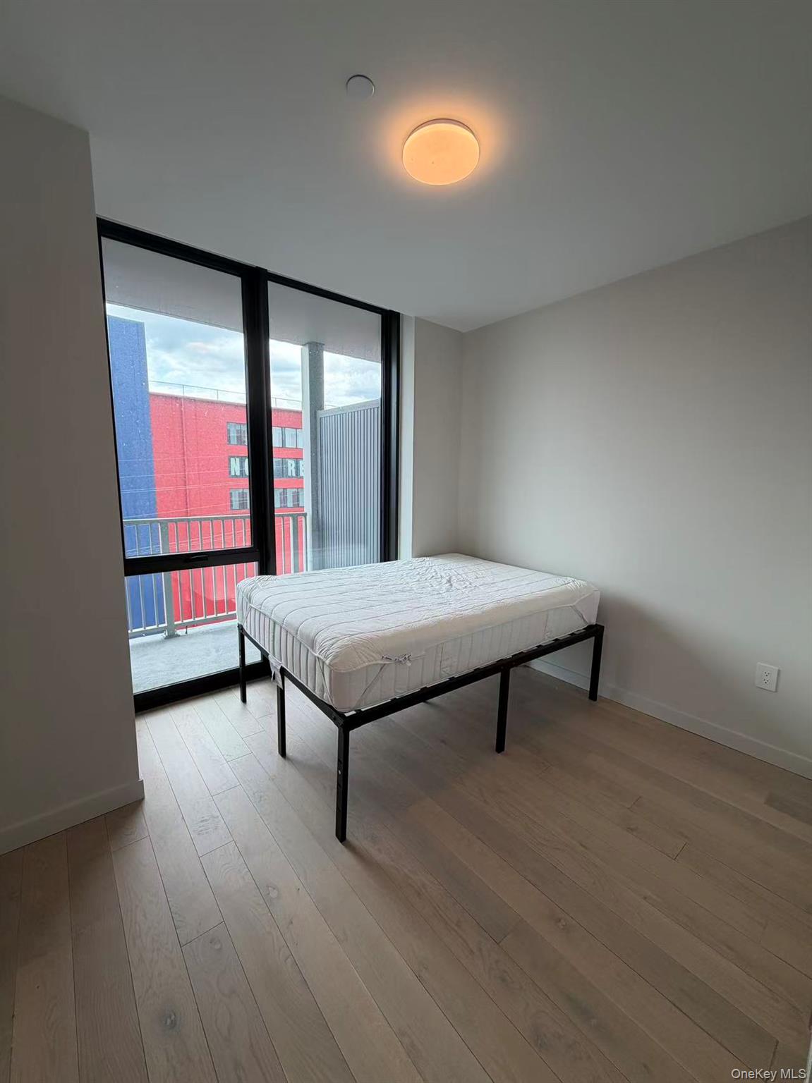 131-02 40th Road, Unit 7O Queens, NY 11354 - Photo 6 of 7 a living room with furniture and a window