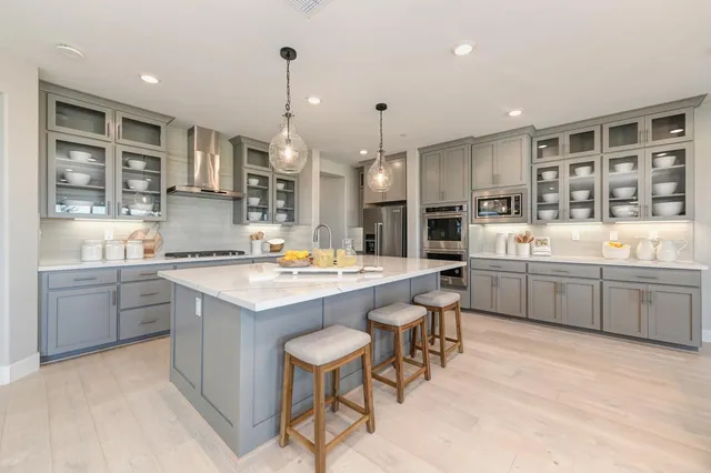 a dining room with kitchen island furniture a chandelier stainless steel appliances and kitchen view