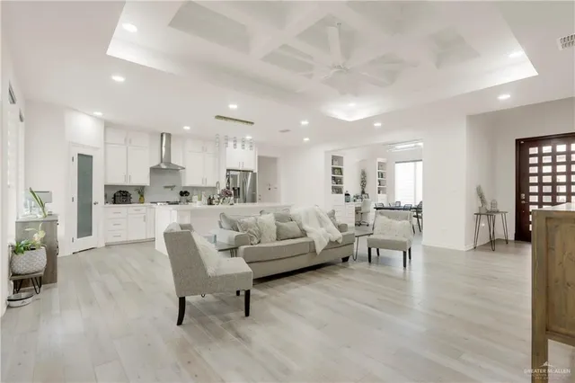 a large white kitchen with white cabinets and wooden floor