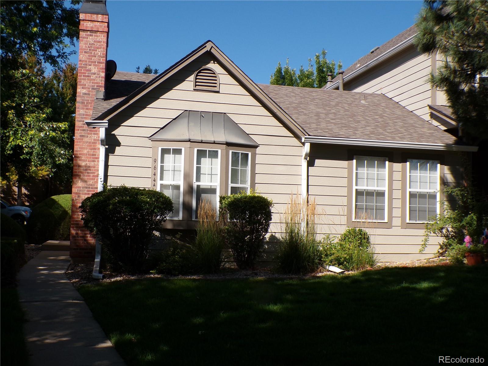 9644 West Chatfield Avenue, Unit A Littleton, CO 80128 - Photo 2 of 11 a front view of a house with a garden