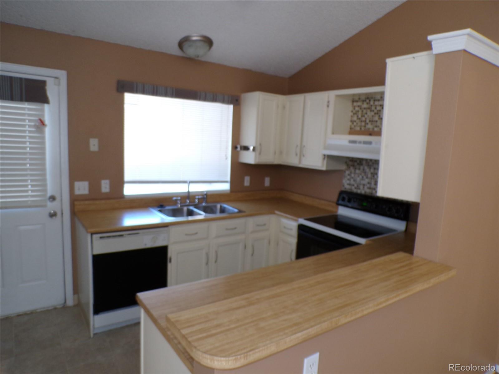9644 West Chatfield Avenue, Unit A Littleton, CO 80128 - Photo 7 of 11 a kitchen with granite countertop cabinets and window