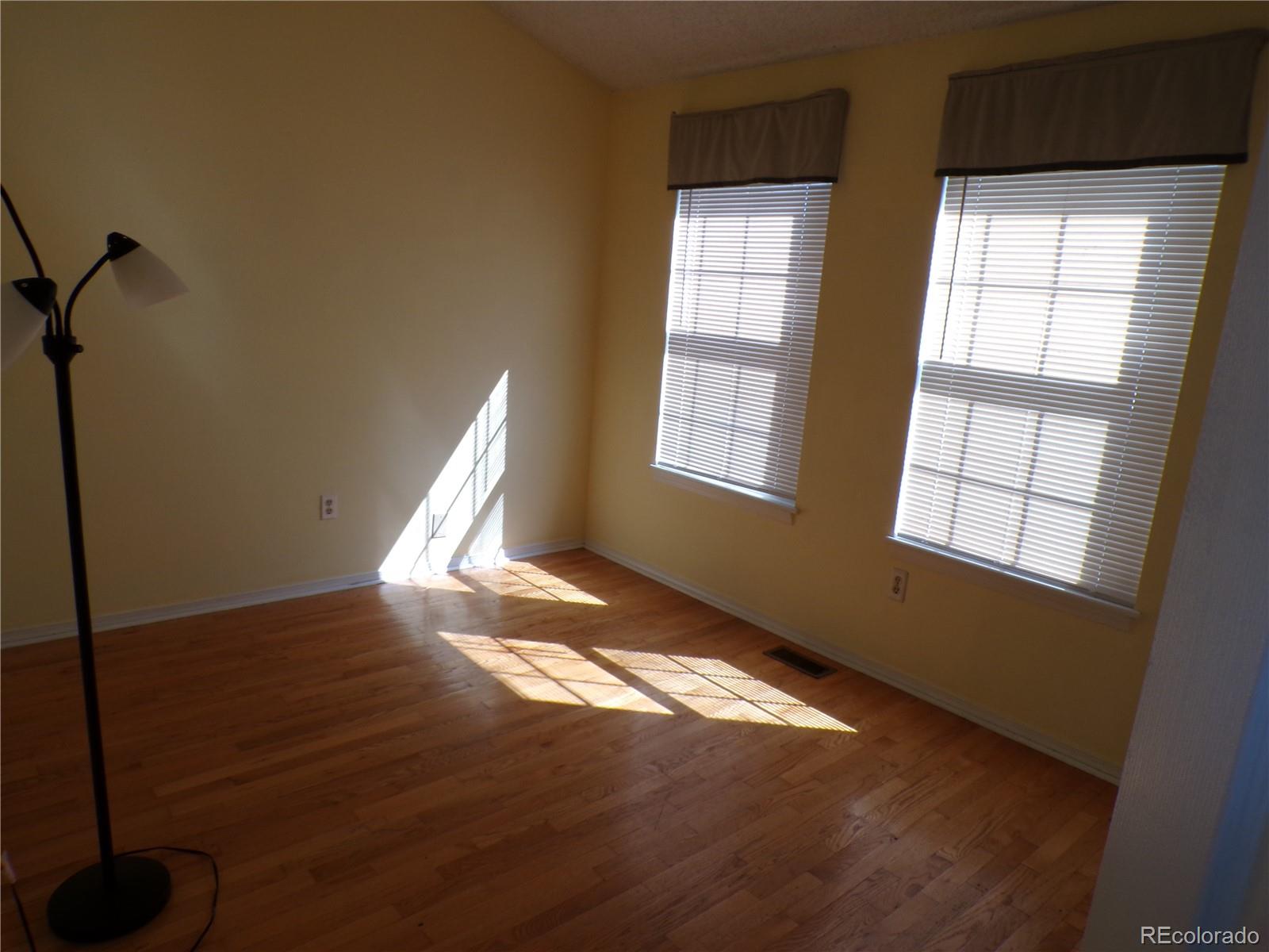 9644 West Chatfield Avenue, Unit A Littleton, CO 80128 - Photo 10 of 11 a view of an empty room with wooden floor and a window