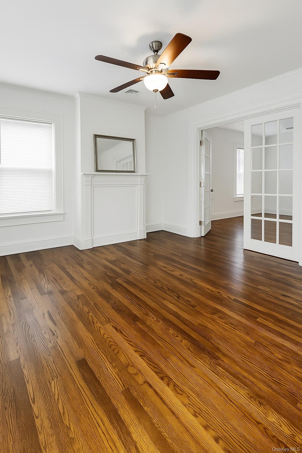 21 Lincoln Avenue, Unit 2 Poughkeepsie, NY 12601 - Photo 2 of 18 an empty room with wooden floor chandelier fan and windows