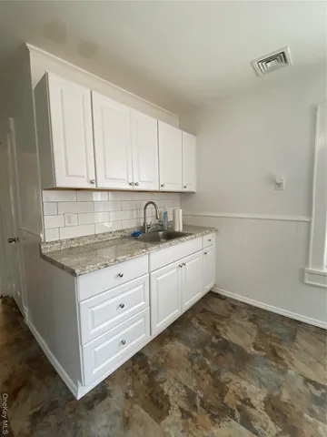 a kitchen with granite countertop white cabinets and white appliances
