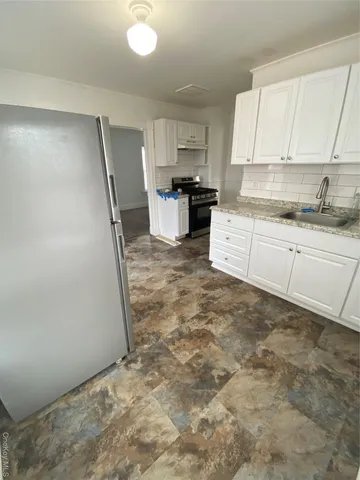 a kitchen with stainless steel appliances granite countertop a refrigerator sink and cabinets