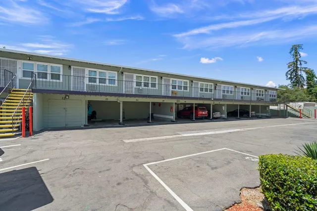 a front view of a building with a garden