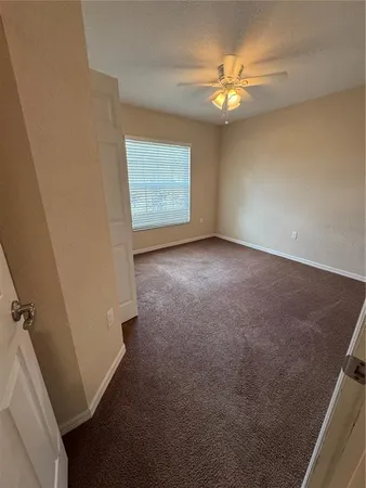an empty room with windows and fan