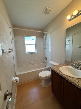 a bathroom with a double vanity sink toilet mirror and bathtub