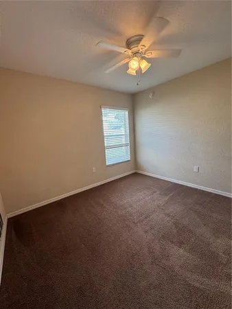 a view of an empty room with a chandelier fan