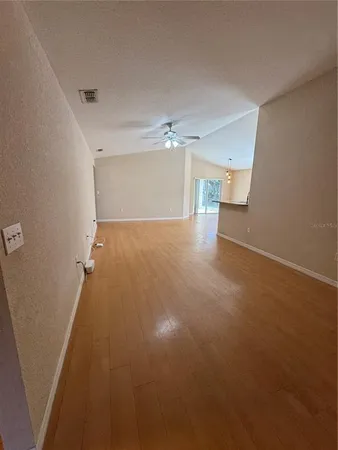 an empty room with a ceiling fan and window