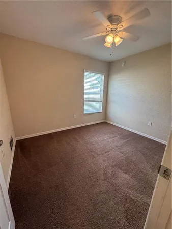 an empty room with a window and a kitchen