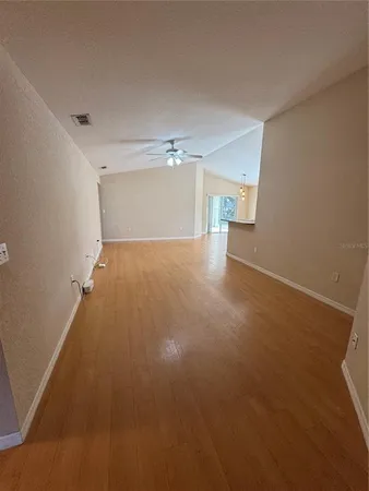 a view of a room with a ceiling fan and window