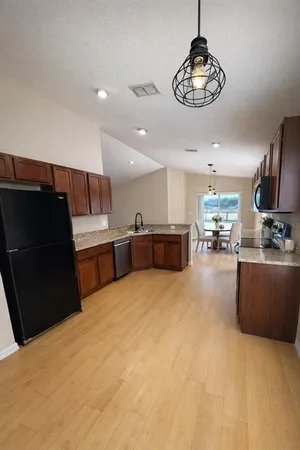 a view of kitchen with refrigerator microwave and stove