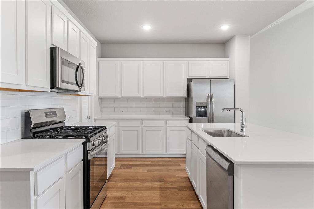 2010 Sandpiper Way Princeton, TX 75407 - Photo 11 of 40 a kitchen with stainless steel appliances granite countertop a sink stove and cabinets