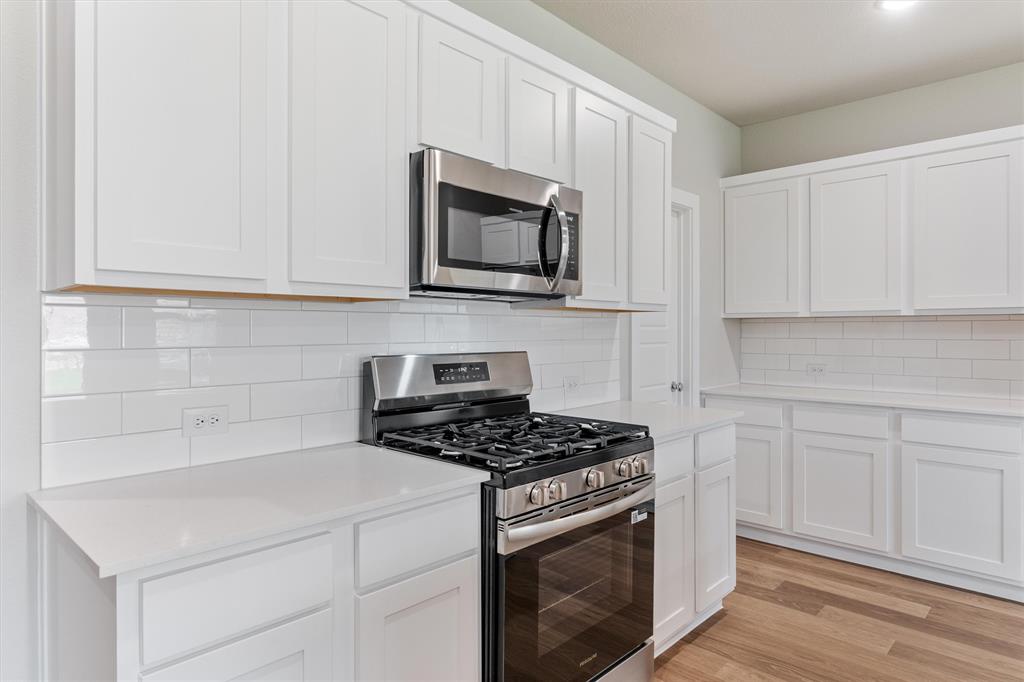 2010 Sandpiper Way Princeton, TX 75407 - Photo 12 of 40 a kitchen with stainless steel appliances granite countertop white cabinets a stove top oven