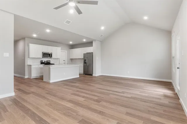 a view of kitchen with granite countertop cabinets and refrigerator