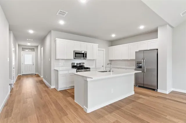 a kitchen with stainless steel appliances a sink stove and refrigerator