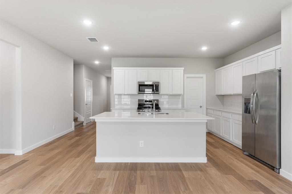 2010 Sandpiper Way Princeton, TX 75407 - Photo 10 of 40 a large kitchen with stainless steel appliances a large counter top a stove and a refrigerator