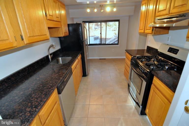 7914 Orange Plank Road Springfield, VA 22153 - Photo 1 of 9 a kitchen with a sink a stove and a refrigerator