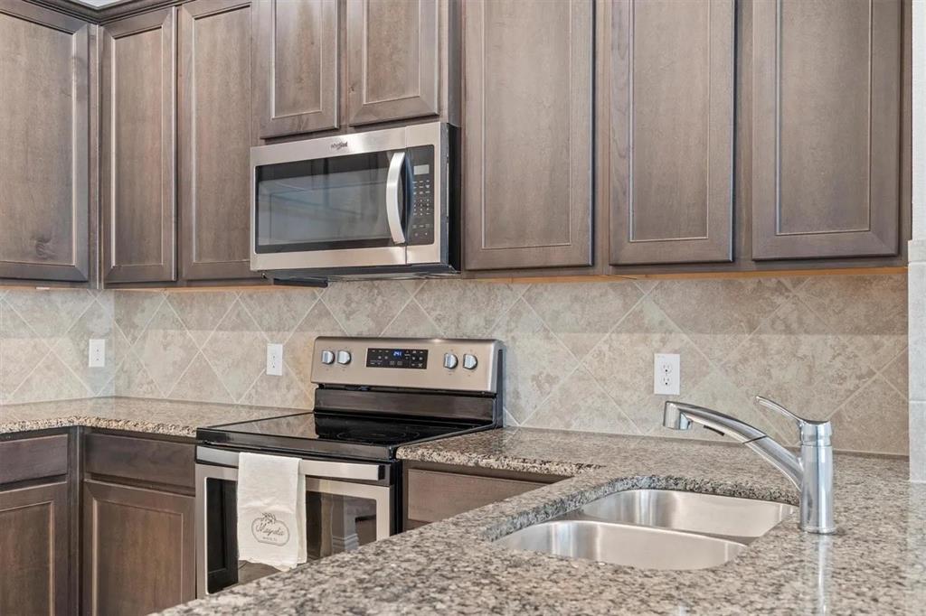 3300 Becker Drive Denton, TX 76207 - Photo 12 of 28 a kitchen with granite countertop a sink stove and cabinets