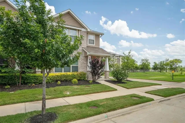 a view of a house next to a yard with big trees