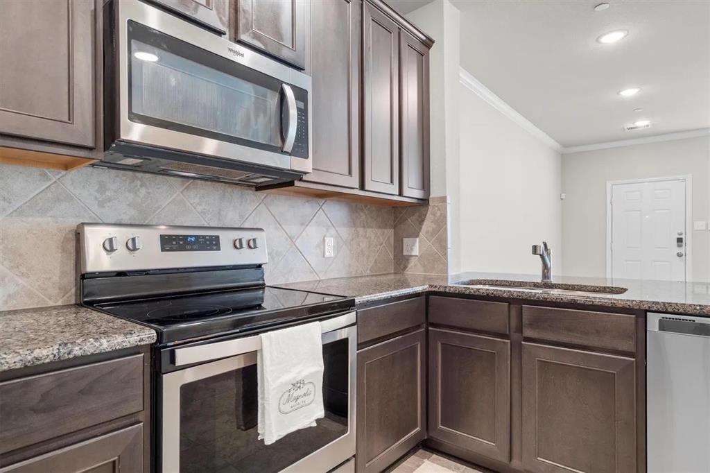 3300 Becker Drive Denton, TX 76207 - Photo 10 of 28 a kitchen with stainless steel appliances granite countertop a stove and a microwave