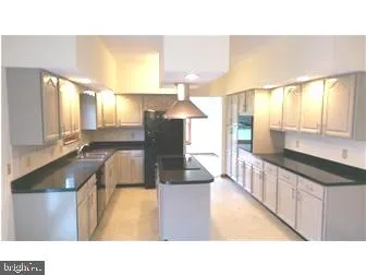 a open kitchen with stainless steel appliances kitchen island granite countertop a sink and cabinets