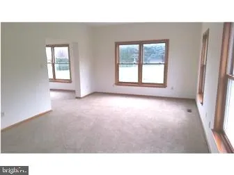 a open hall with a floor to ceiling window and a wooden floor