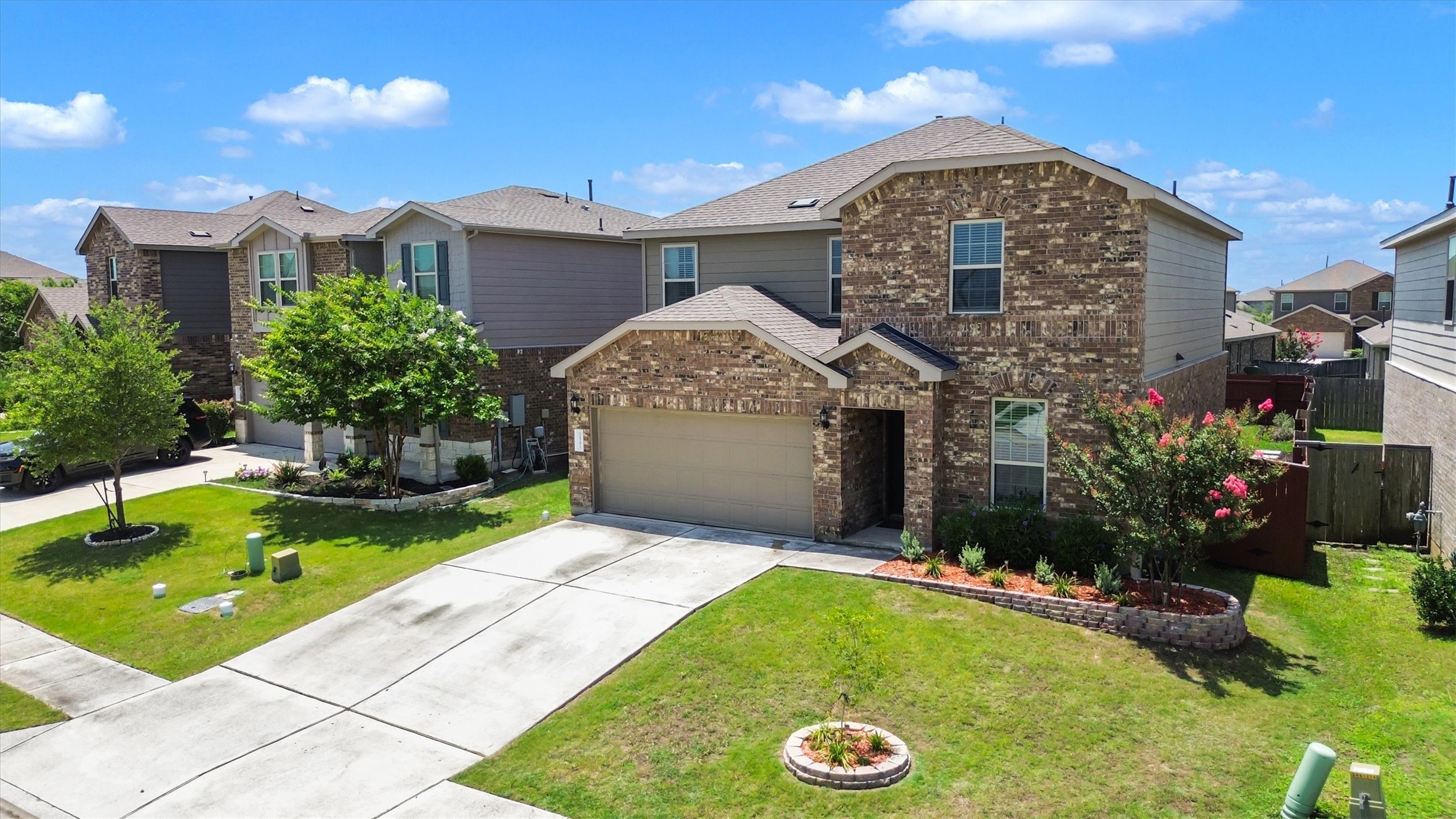 11701 Jackson Falls Way Manor, TX 78653 - Photo 34 of 40 A well-maintained lawn and tasteful landscaping complement this charming brick-front home with an integrated garage.