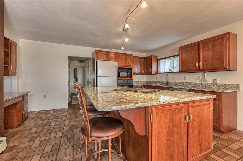 18 Rhea Road Indiana, PA 15701 - Photo 5 of 39 a kitchen with granite countertop sink and wooden cabinets