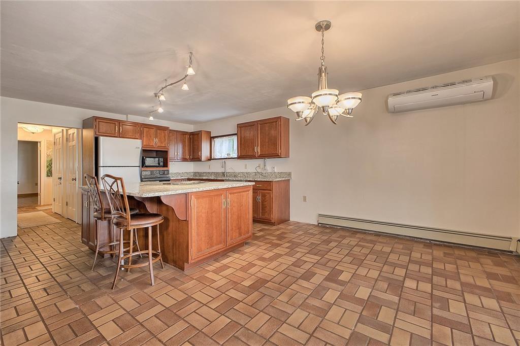 18 Rhea Road Indiana, PA 15701 - Photo 8 of 39 a open kitchen with stainless steel appliances granite countertop a sink dishwasher a stove a refrigerator with a dining table and chairs