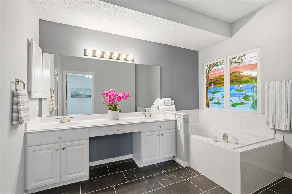 14584 Blueberry Court Addison, TX 75001 - Photo 23 of 40 a spacious bathroom with a sink double vanity granite and a mirror