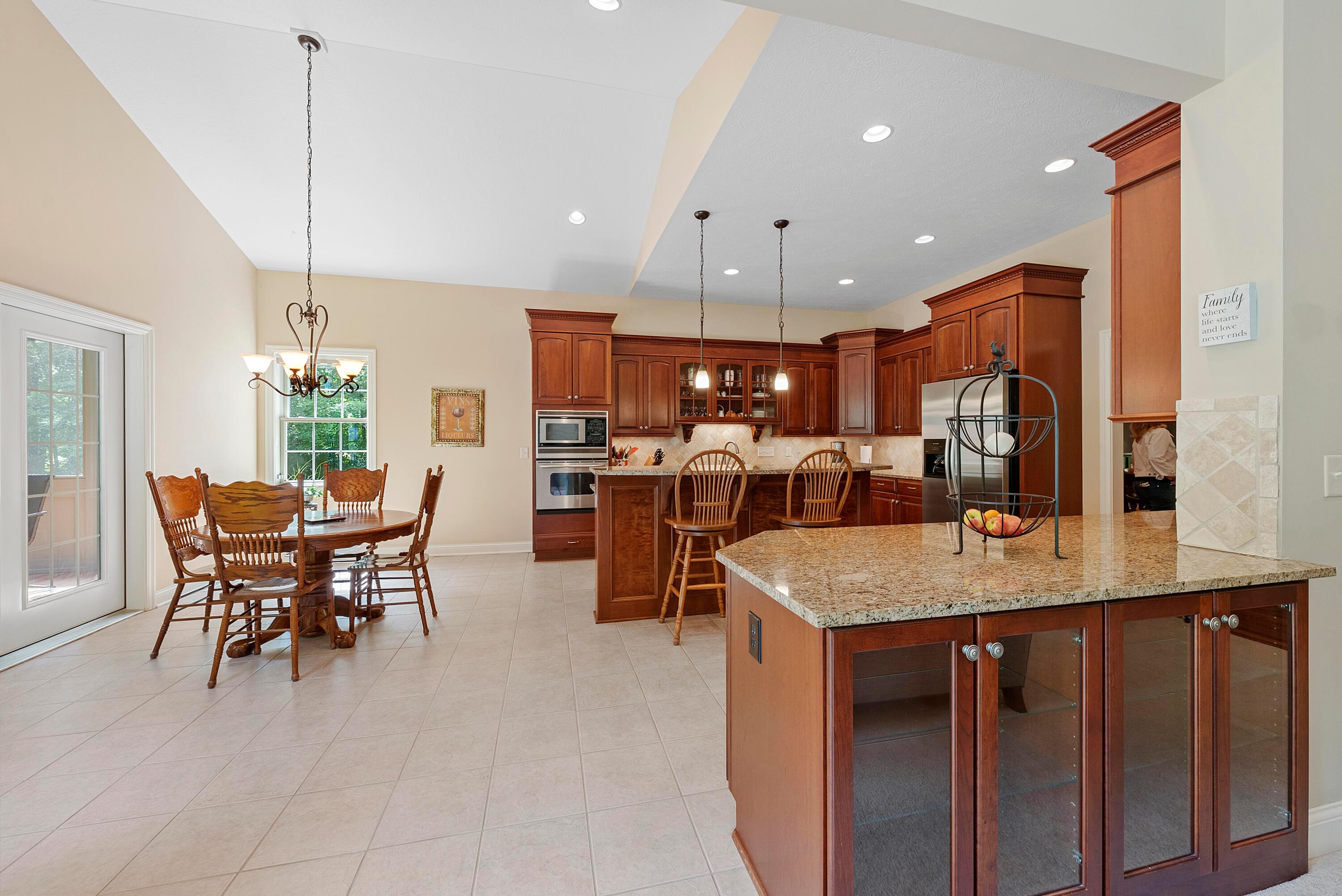 5761 Hughes Road Galena, OH 43021 - Photo 15 of 43 Expansive, well-appointed Kitchen is equipped with upscale stainless steel appliances including a GE Profile dishwasher, GE Profile wall oven and microwave, KitchenAid refrigerator, and a GE Profile 5-burner smooth surface cooktop with retractable fan, located in the island.