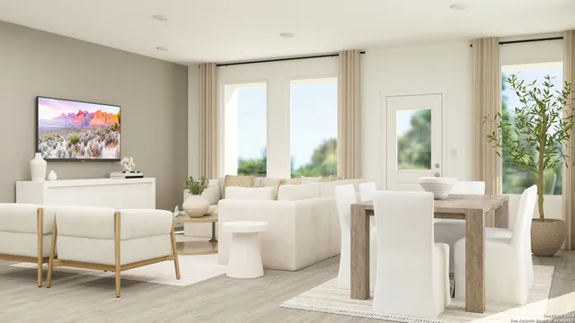 a living room with furniture a large window and a potted plant