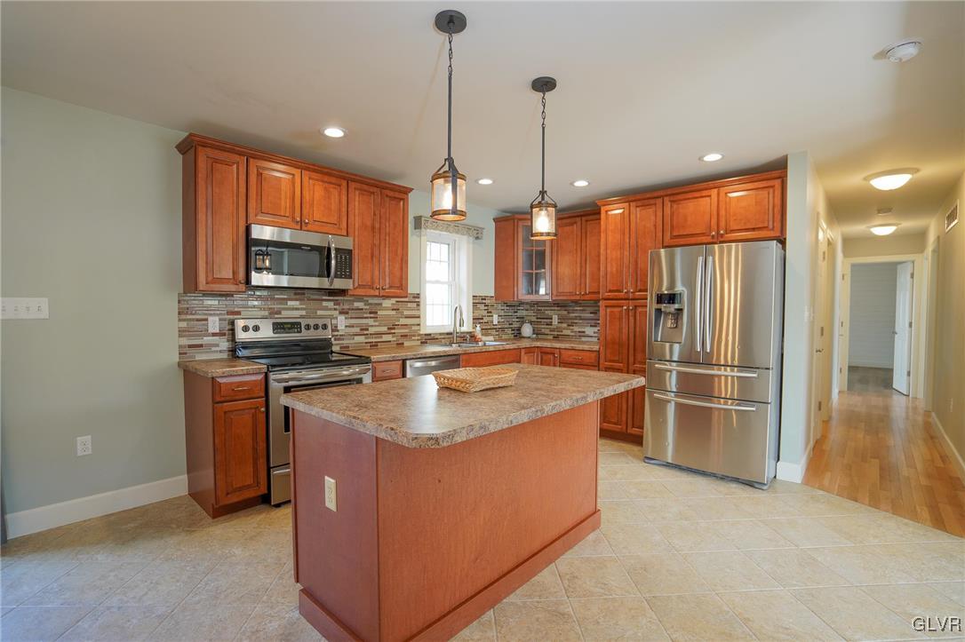 259 Owl Creek Road Tamaqua, PA 18252 - Photo 11 of 50 a kitchen with stainless steel appliances granite countertop a stove a sink a refrigerator and a wooden floor