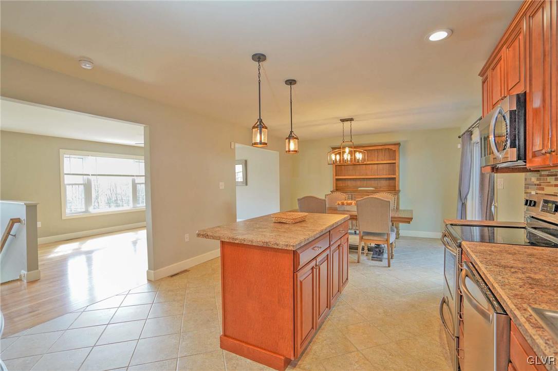 259 Owl Creek Road Tamaqua, PA 18252 - Photo 15 of 50 a open kitchen with stainless steel appliances granite countertop a stove top oven a sink dishwasher and couches with wooden floor