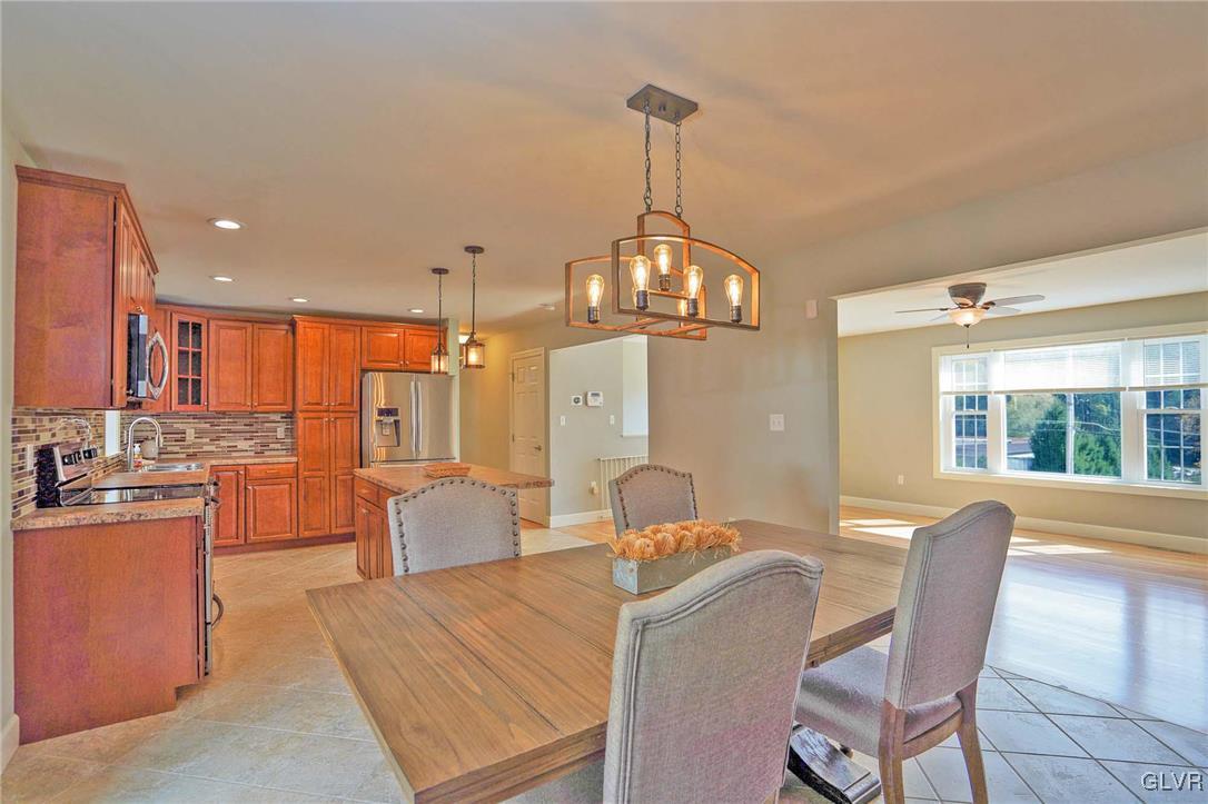 259 Owl Creek Road Tamaqua, PA 18252 - Photo 16 of 50 a open kitchen with stainless steel appliances granite countertop a stove top oven a dining table and chairs with wooden floor