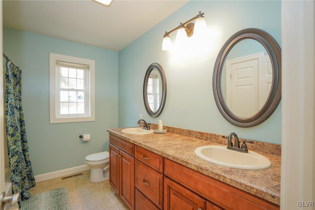 259 Owl Creek Road Tamaqua, PA 18252 - Photo 20 of 50 a bathroom with a granite countertop toilet a sink and a mirror