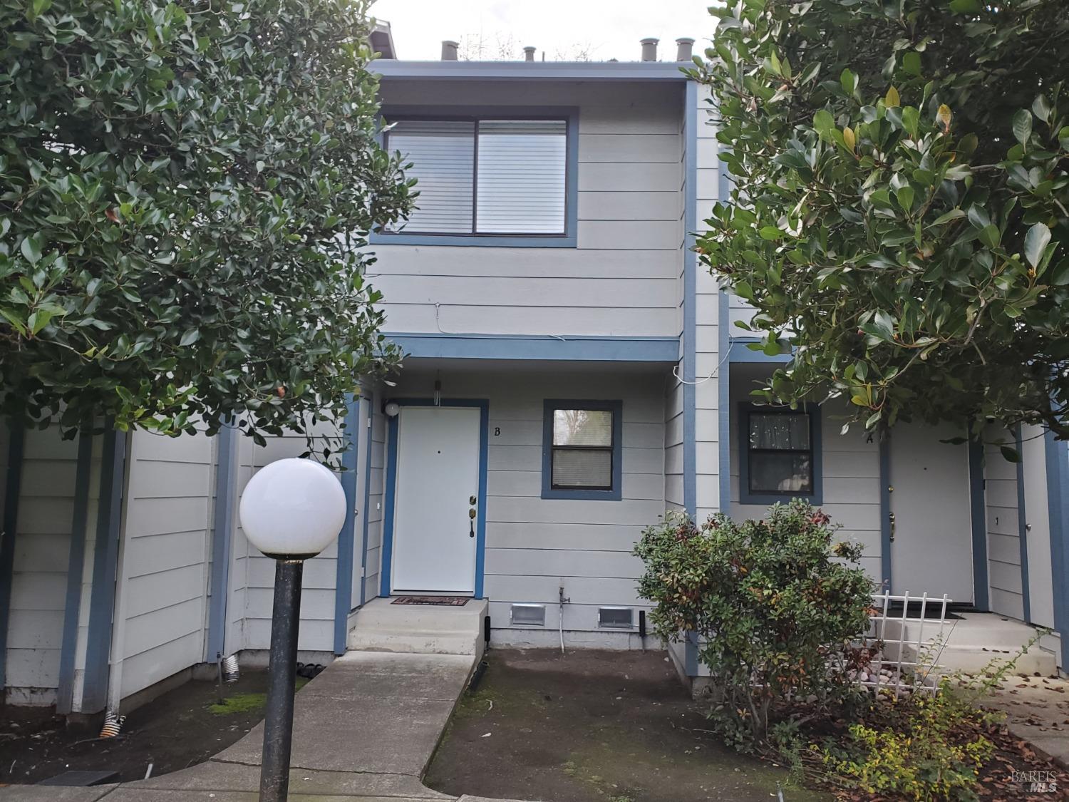 2167 Meadowbrook Court, Unit B Santa Rosa, CA 95403 - Photo 1 of 1 a front view of a house with a fountain and large tree