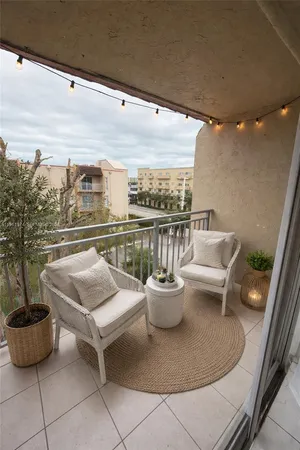 a view of a balcony with chairs and a potted plant