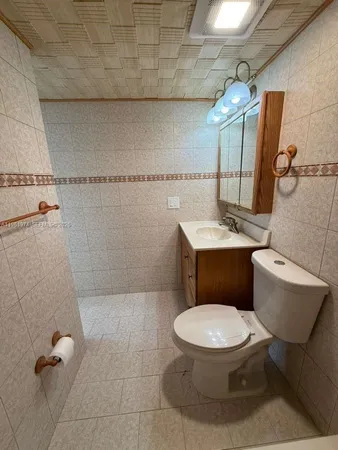a white toilet sitting next to a bathroom sink