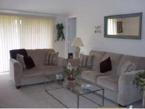 823 Northeast Brae, Unit 5 Palm Bay, FL 32905 - Photo 3 of 4 a living room with furniture and a large window