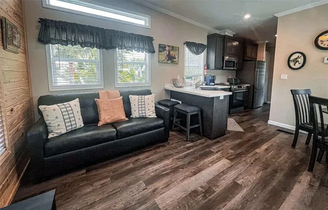 a living room with furniture and a open kitchen view